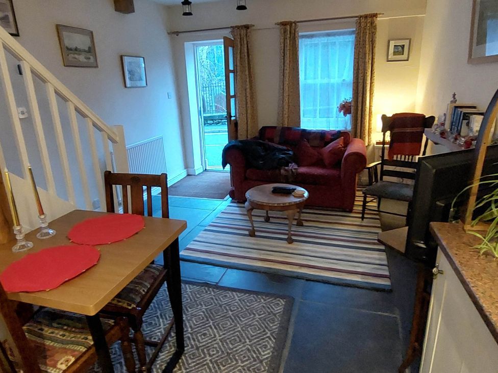 A living room with a sofa and dining table at Cosy Cottage for two in the centre of Sedbergh