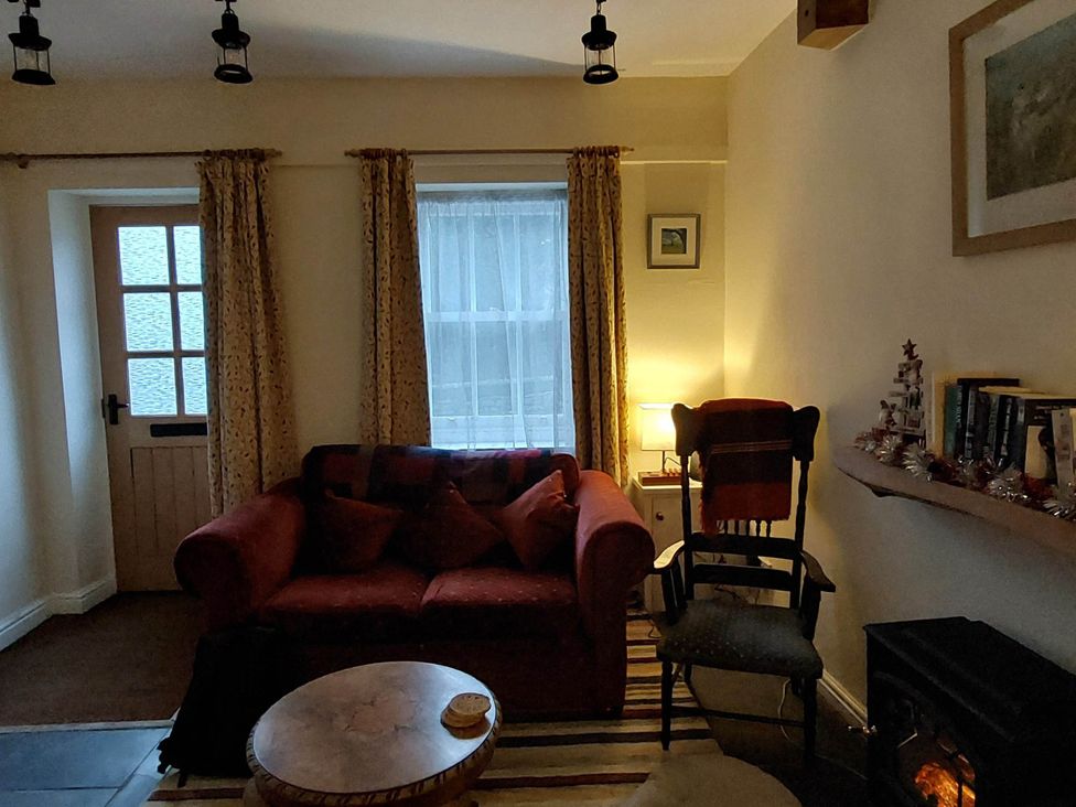 A living room with a sofa and lamp at Cosy Cottage for two in the centre of Sedbergh