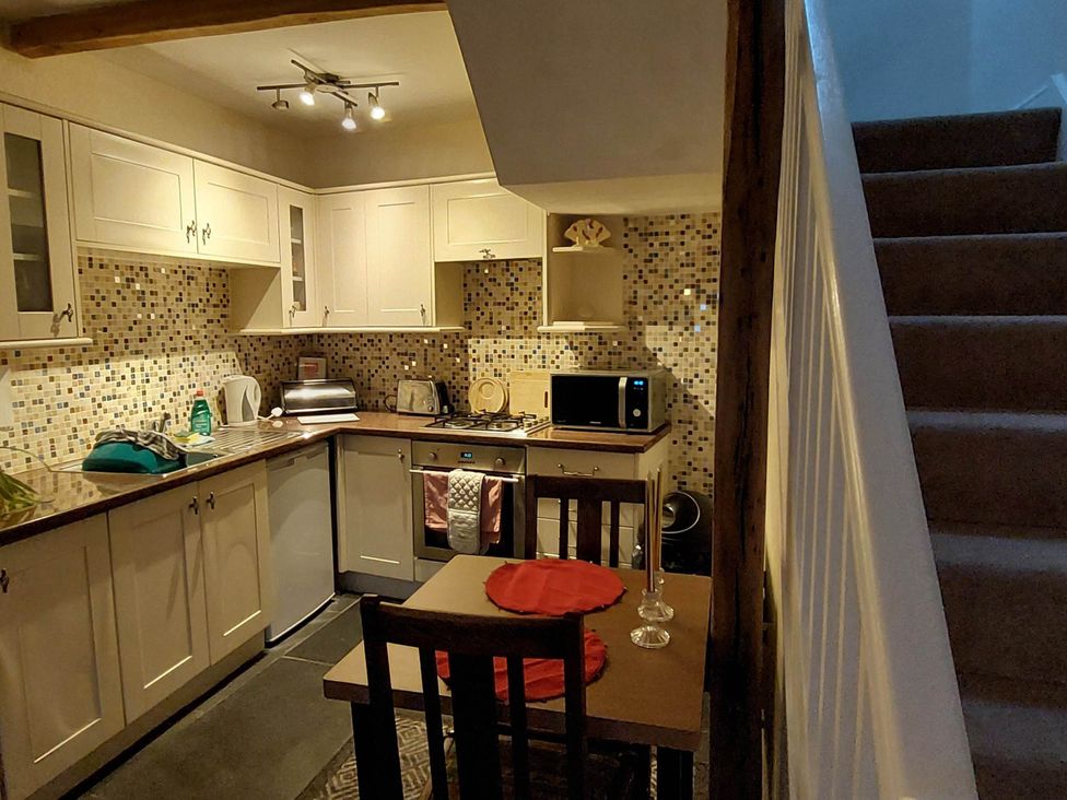 A kitchen with cabinets and appliances at Cosy Cottage for two in the centre of Sedbergh