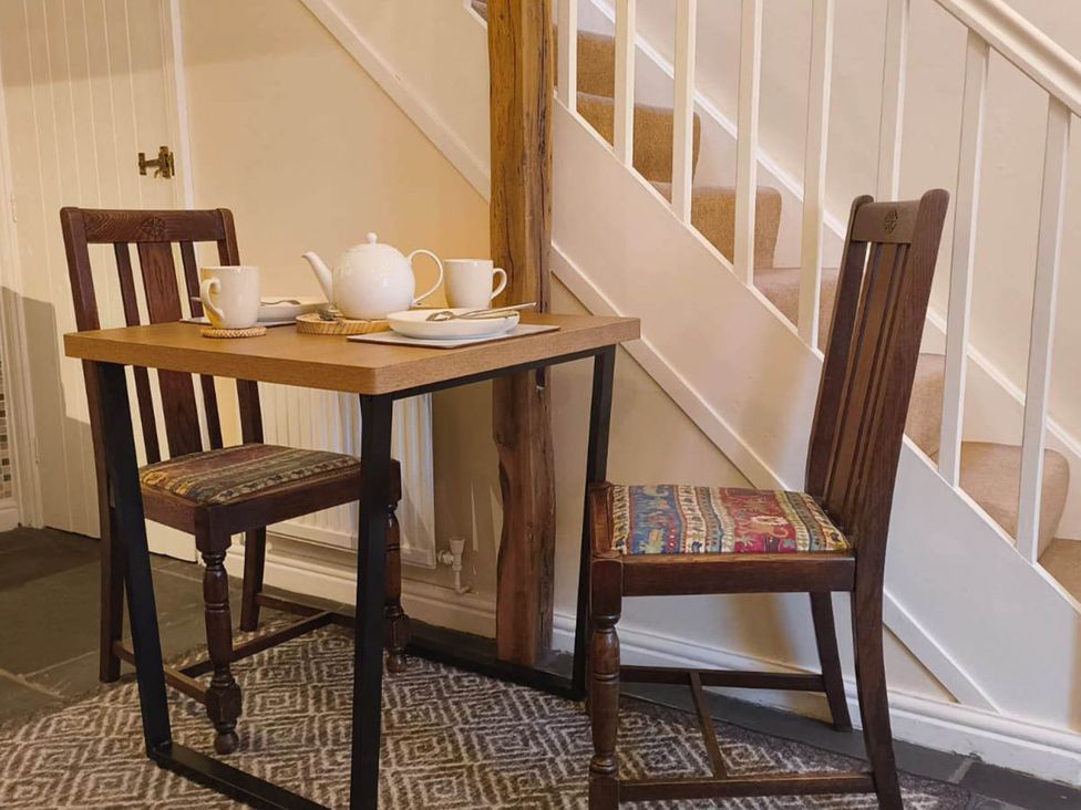 A dining area with a table and chairs at Cosy Cottage for two in the centre of Sedbergh