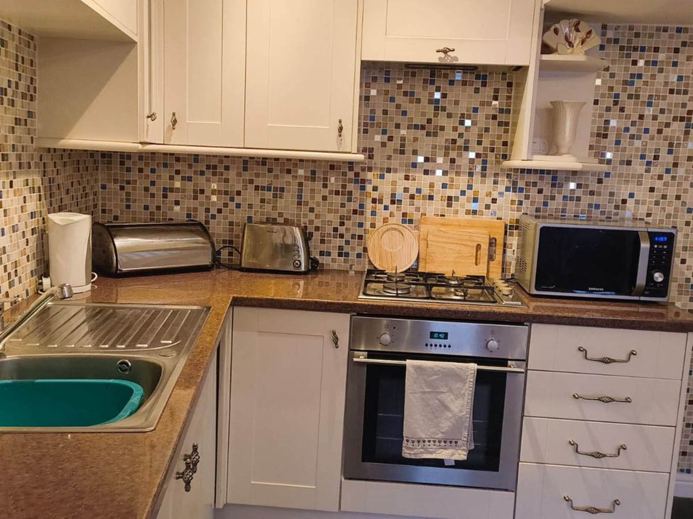 A kitchen with appliances and utensils at Cosy Cottage for two in the centre of Sedbergh