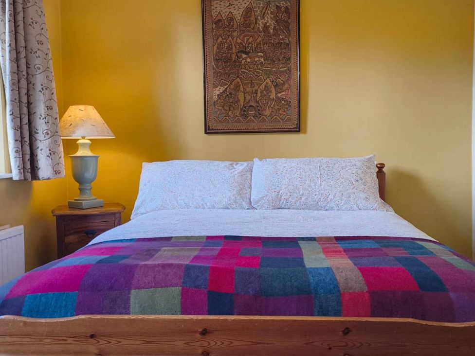 A bedroom with a bed and lamp at Cosy Cottage for two in the centre of Sedbergh