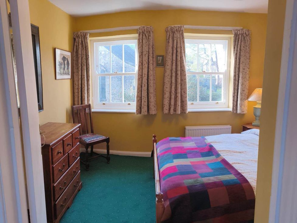 A bedroom with a double bed and dresser at Cosy Cottage for two in the centre of Sedbergh
