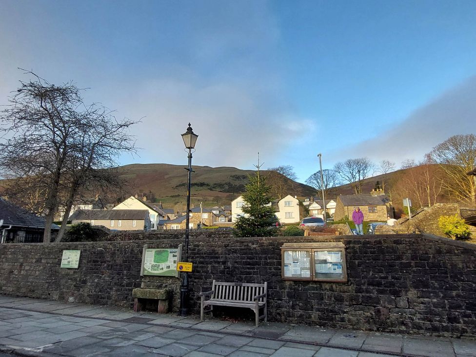 An outdoor scene with a bench and trees at Cosy Cottage for two in the centre of Sedbergh