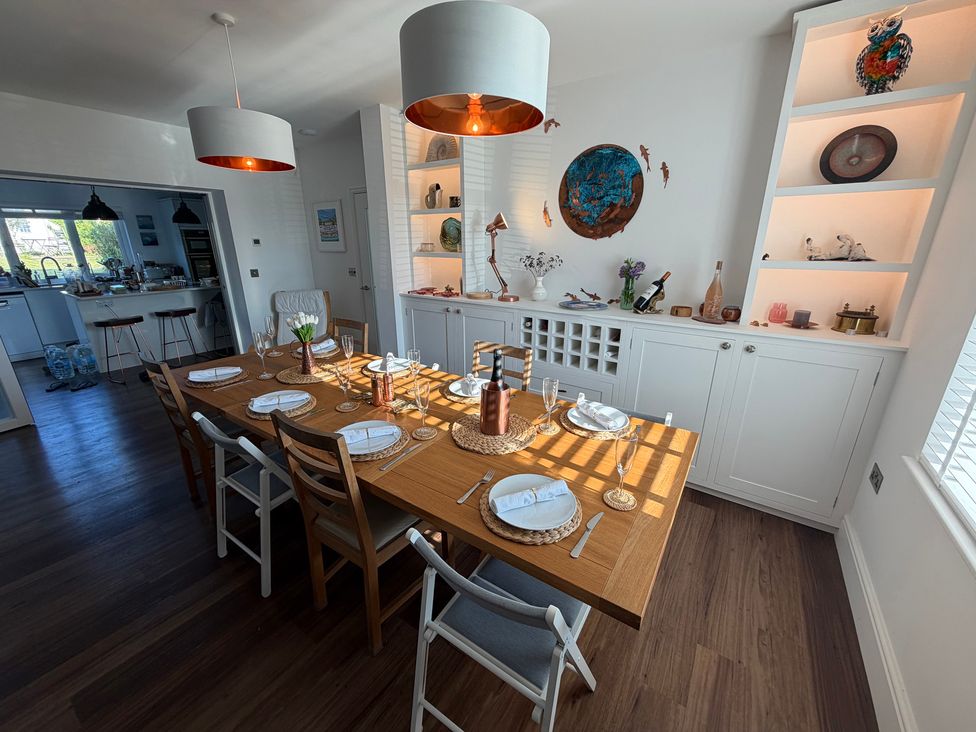 A dining room with a table set for meals at Lorrell in Salcombe