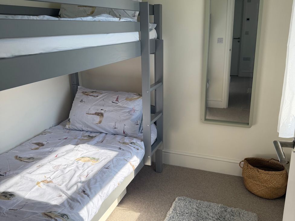 A bedroom with a bunk bed and mirror at Lorrell in Salcombe