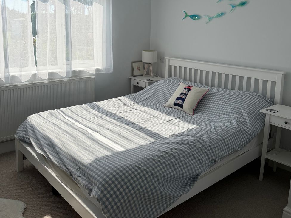 A bedroom with a bed and bedside table at Lorrell in Salcombe