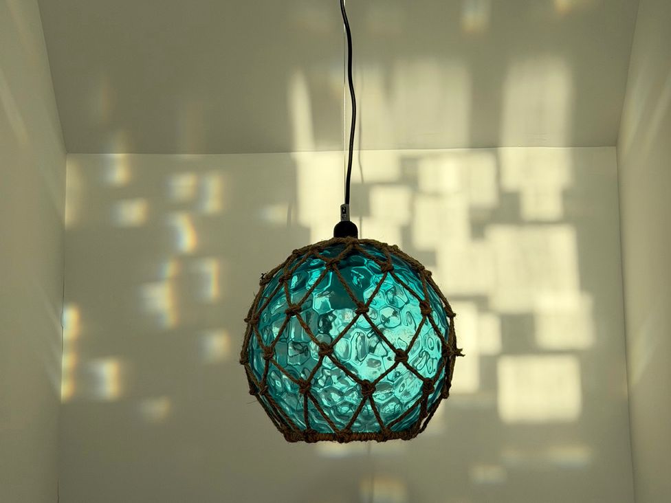A hanging light with a glass shade at Lorrell in Salcombe