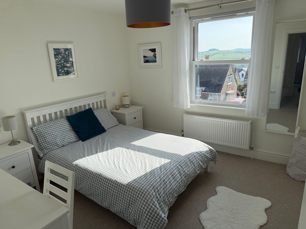 A bedroom with a bed and desk at Lorrell in Salcombe