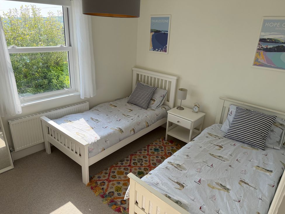 A bedroom with two beds and a window at Lorrell in Salcombe