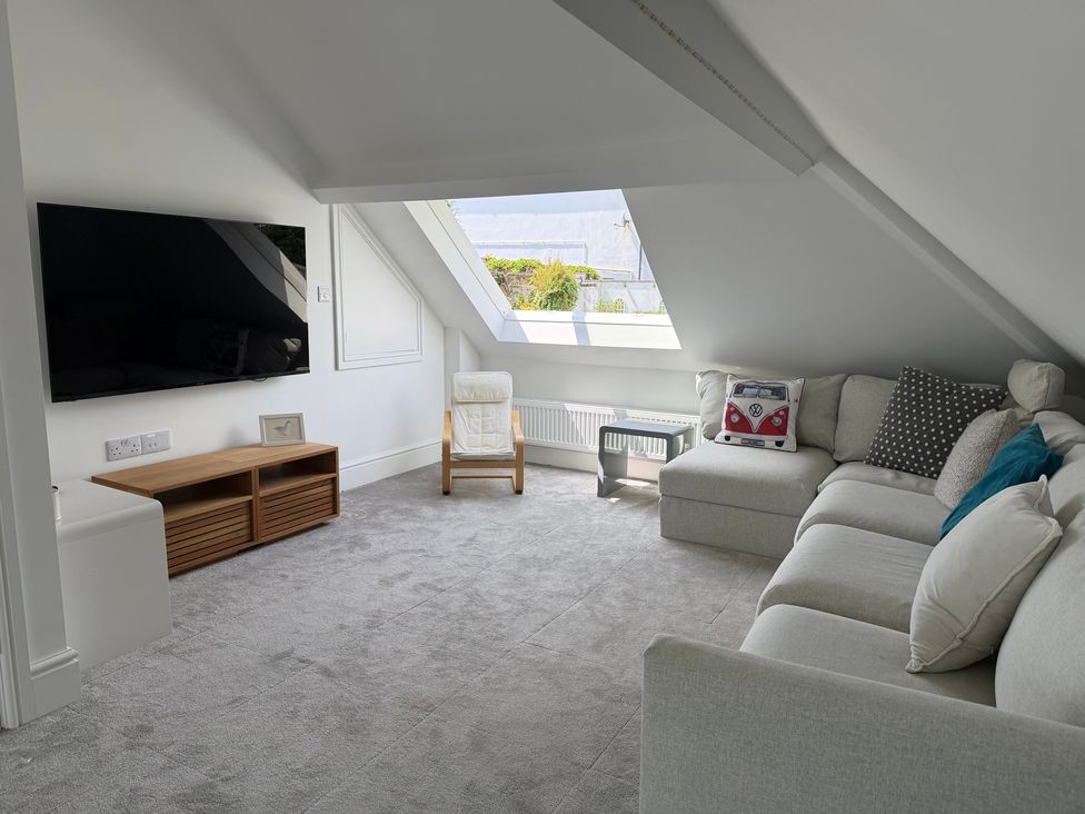 A living room with a television and sofa at Lorrell in Salcombe