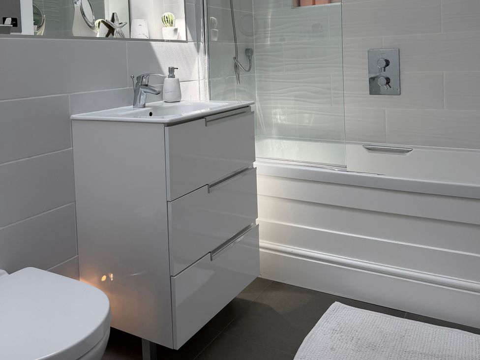 A bathroom featuring a sink, toilet, and bathtub at Lorrell in Salcombe
