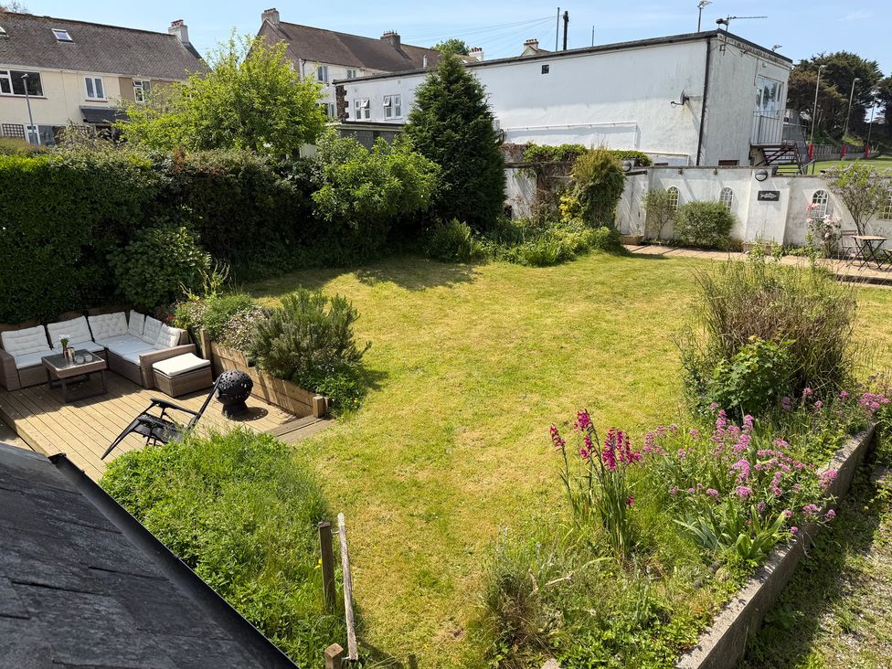 A garden with seating area and flowerbed at Lorrell in Salcombe