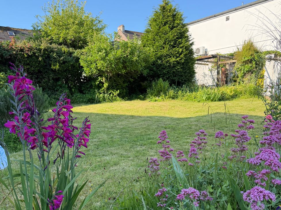 A garden with flowers and grass at Lorrell in Salcombe