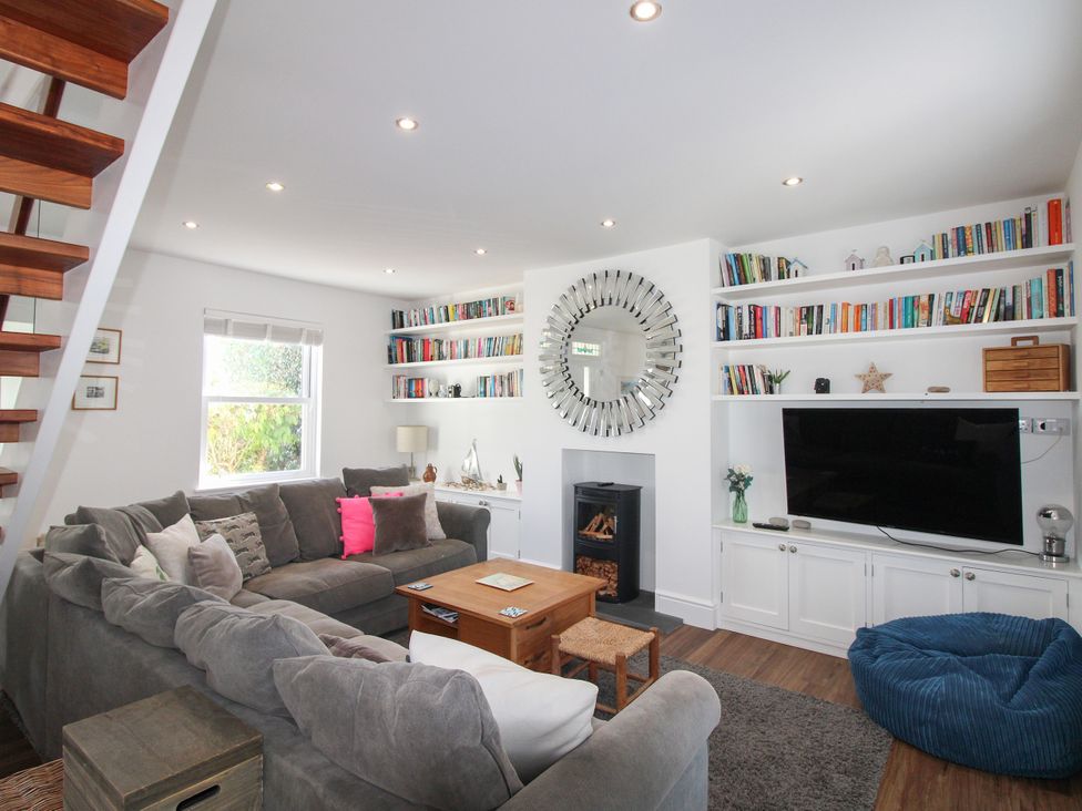 A living room with a sofa, coffee table, and television at Lorrell in Salcombe