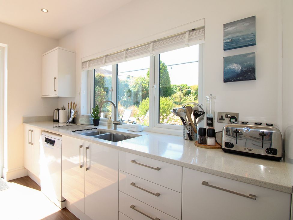 A kitchen with a sink and a dishwasher at Lorrell in Salcombe