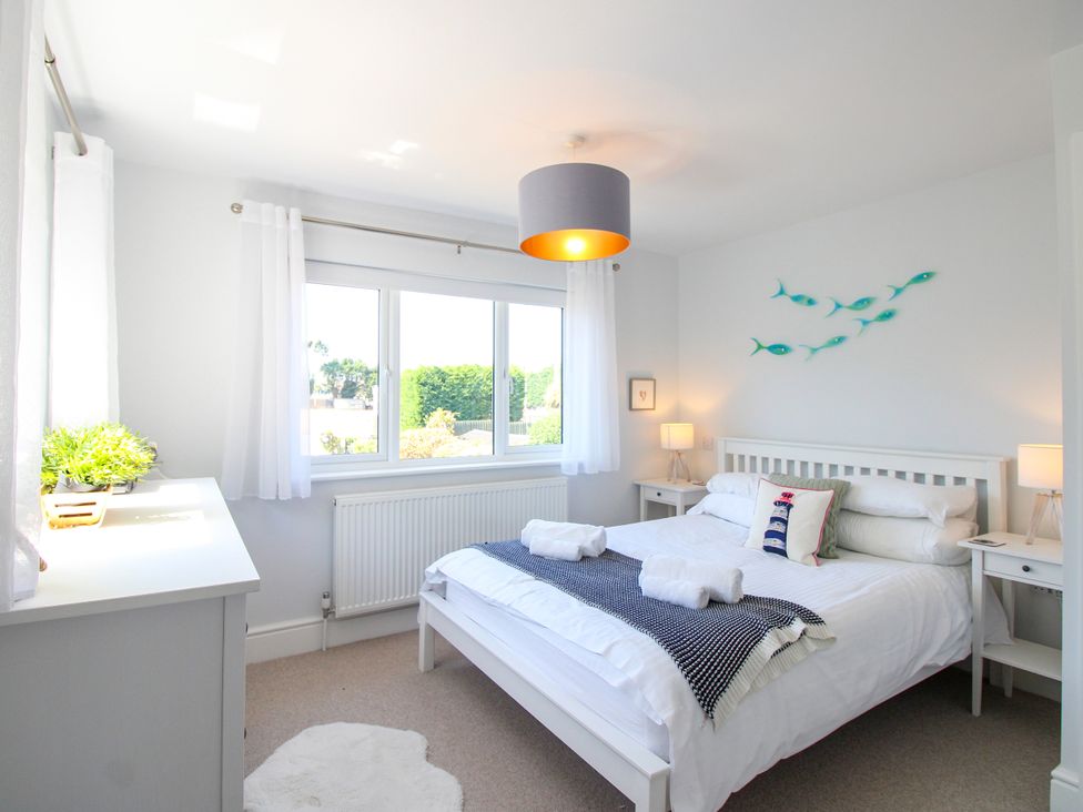 A bedroom with a bed and bedside tables at Lorrell in Salcombe