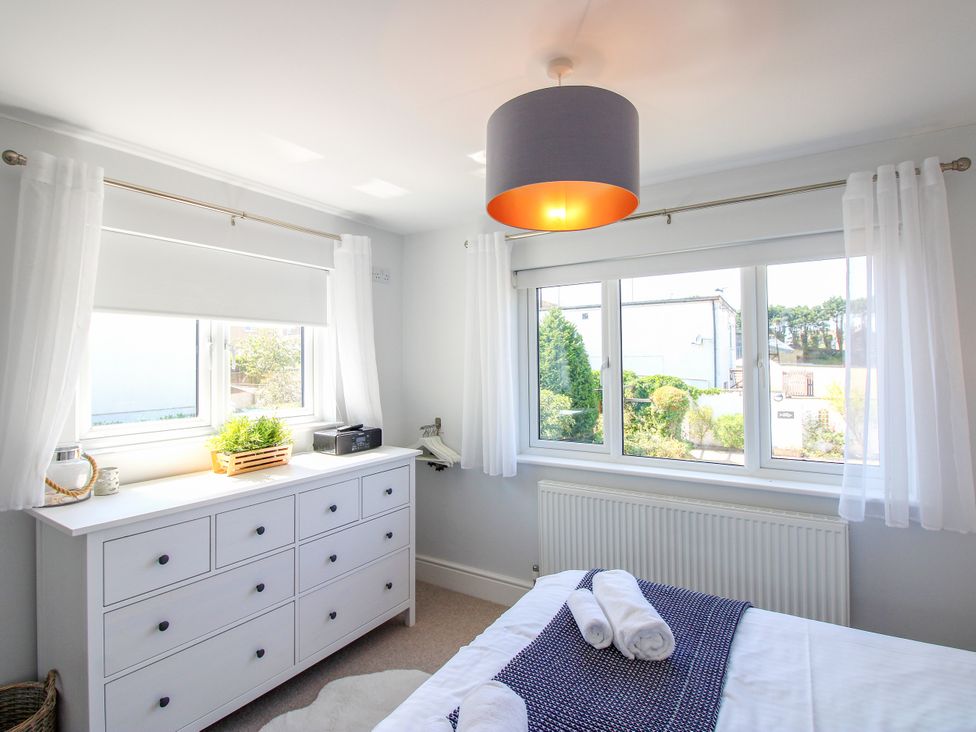 A bedroom with a bed and dresser at Lorrell in Salcombe