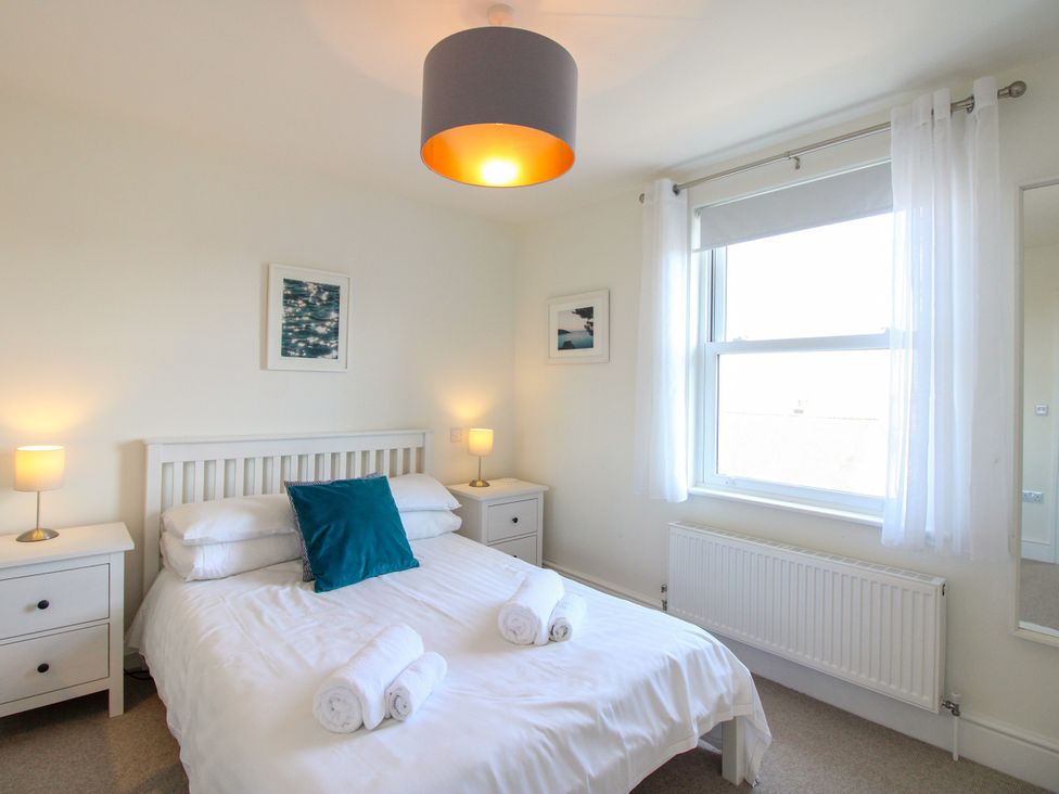 A bedroom with a bed and lamps at Lorrell in Salcombe