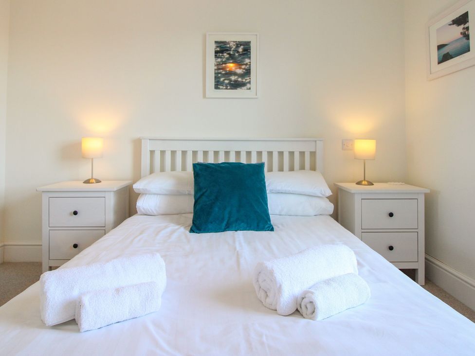 A bedroom with a bed and lamps at Lorrell Salcombe