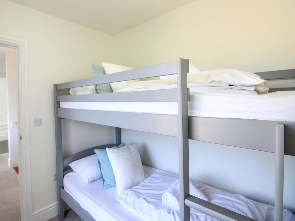 A bunk bed with pillows and towels at Lorrell in Salcombe