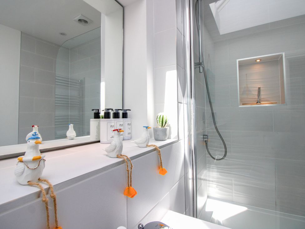 A bathroom with a shower and decorative items at Lorrell in Salcombe