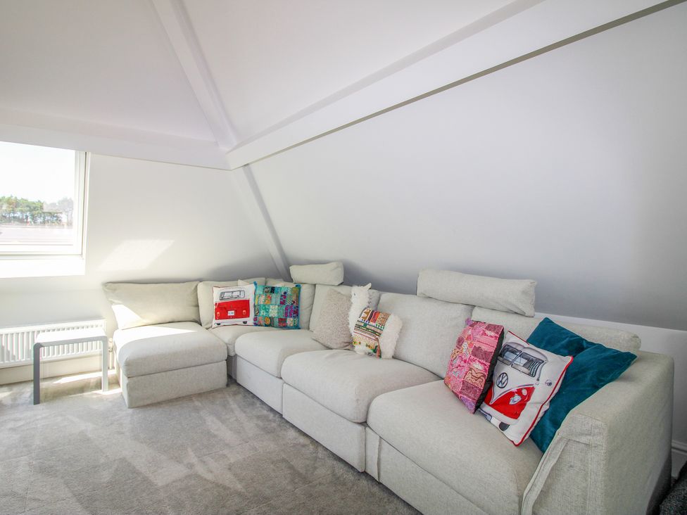 A living room with a sectional sofa and cushions at Lorrell in Salcombe