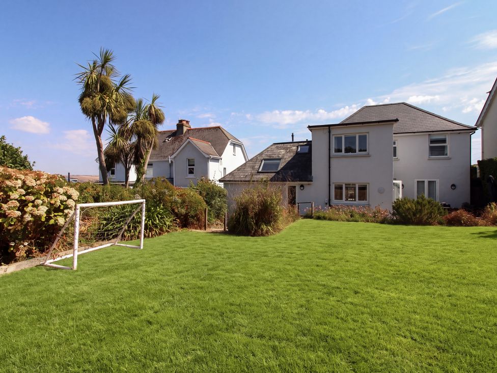 A garden with a goalpost and palm trees at Lorrell in Salcombe
