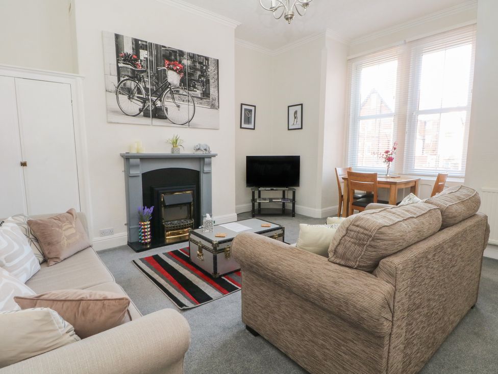 A living room with a television and dining table at Apartment 2 in Lytham St. Annes