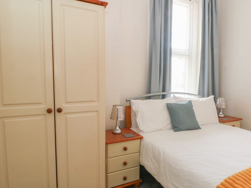 A bedroom with a bed and wardrobe at Apartment 2 in Lytham St. Annes