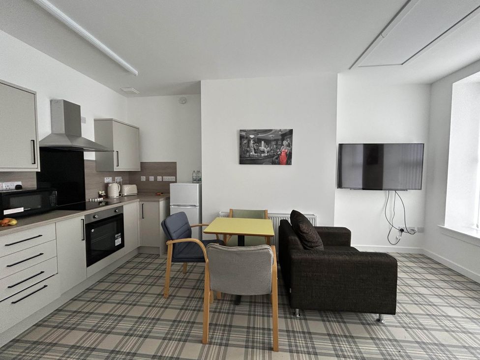 A living room with kitchen units and a table at Buckie Haven 3 Bed Contractors Business Travellers in Buckie