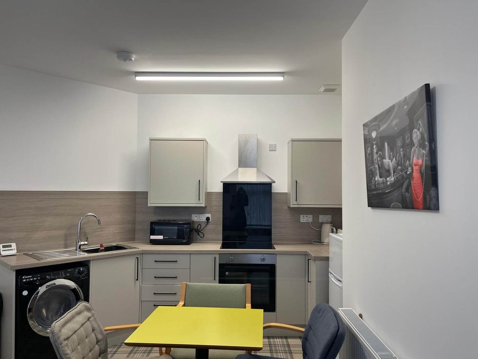 A kitchen with appliances and a dining table at Buckie Haven 3 Bed Contractors Business Travellers in Buckie