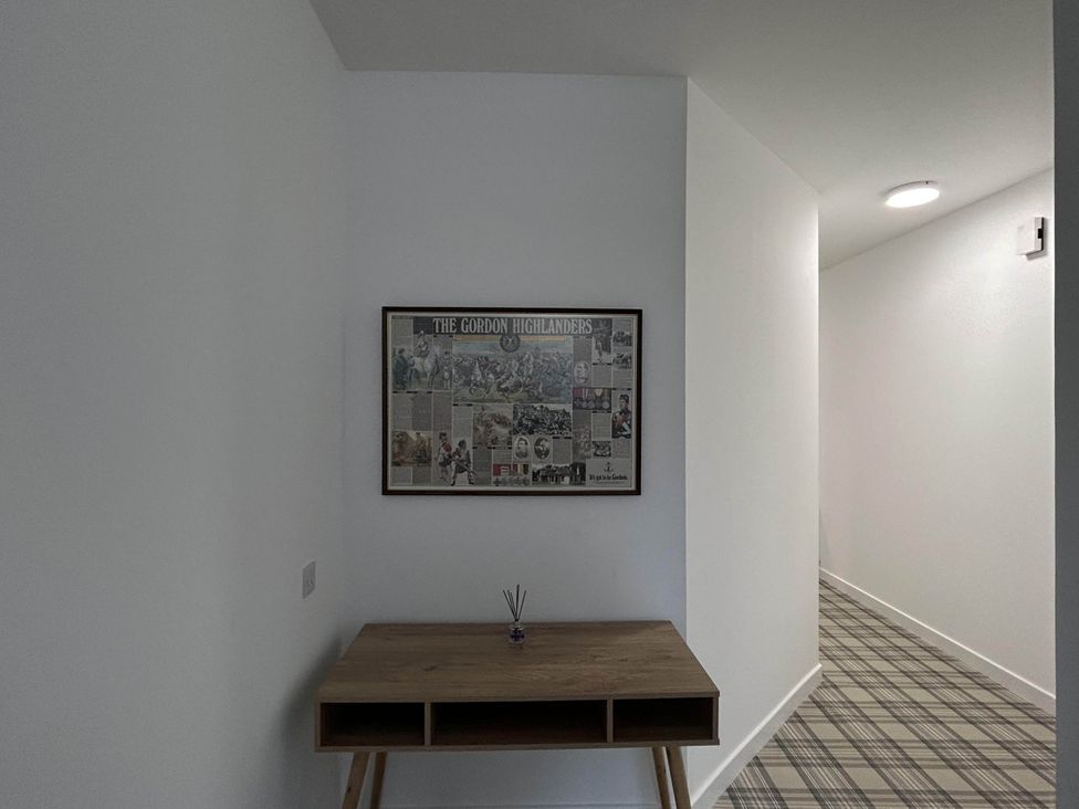 A hallway with a table and a framed picture at Buckie Haven 3 Bed Contractors Business Travellers, Buckie