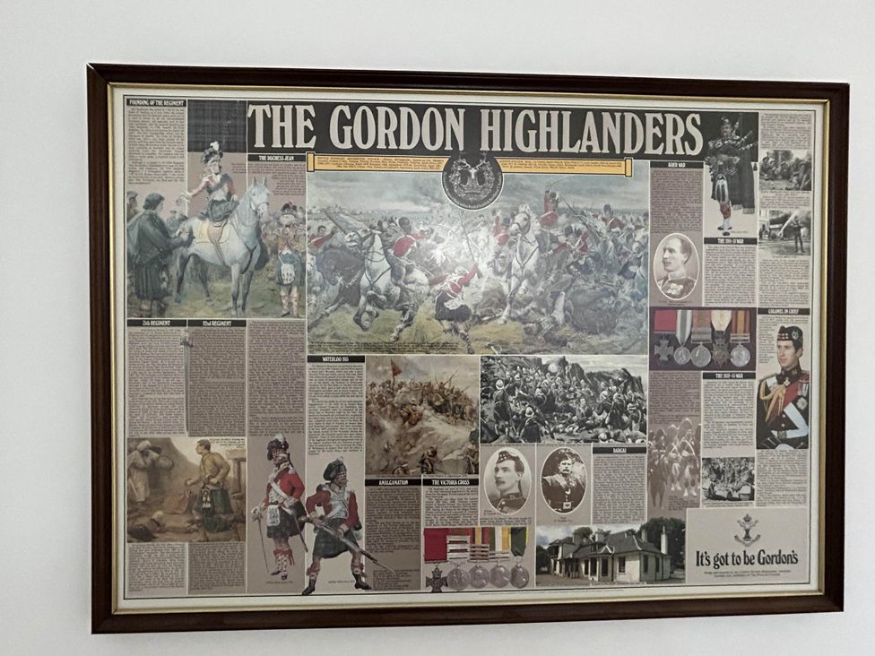 A framed display of military history featuring articles and images of the Gordon Highlanders