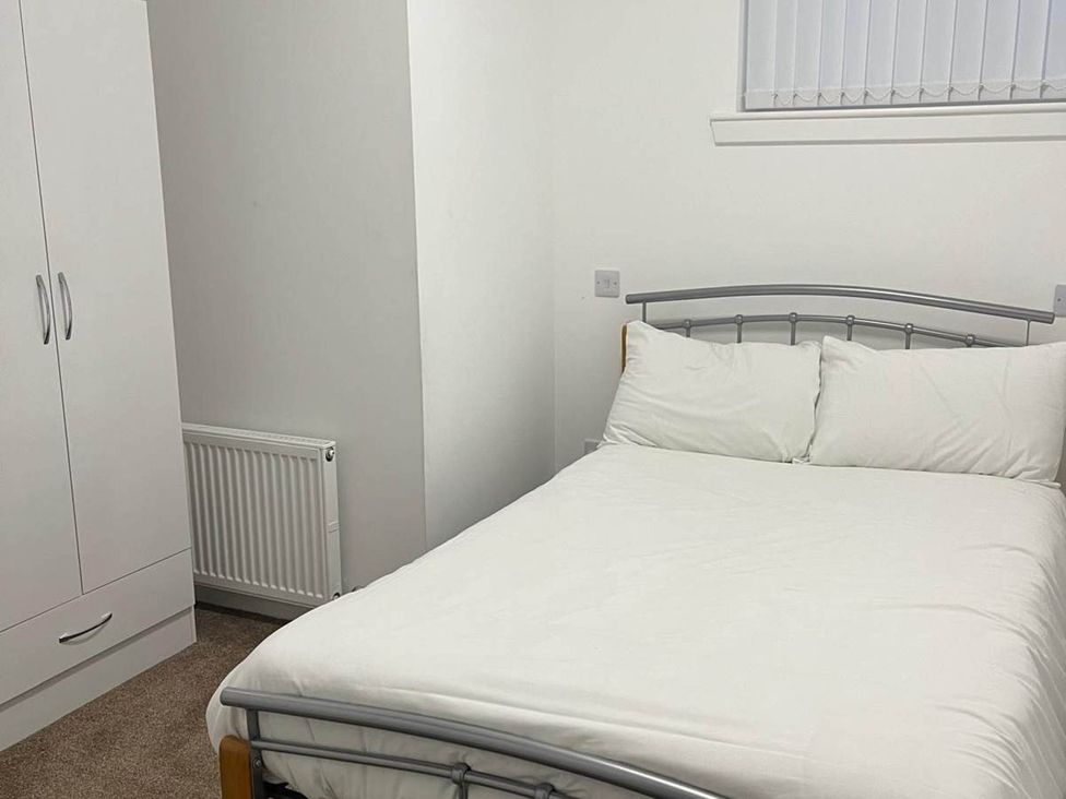 A bedroom with a bed and wardrobe at Buckie Haven 3 Bed Contractors Business Travellers, Buckie