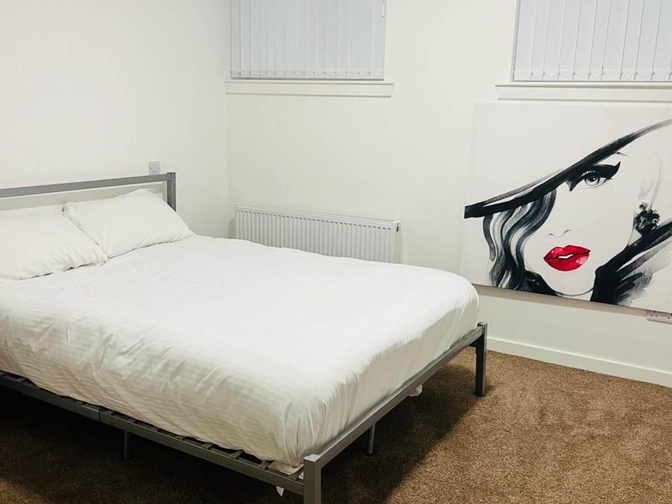 A bedroom with a bed and artwork on the wall at Buckie Haven 3 Bed Contractors Business Travellers in Buckie