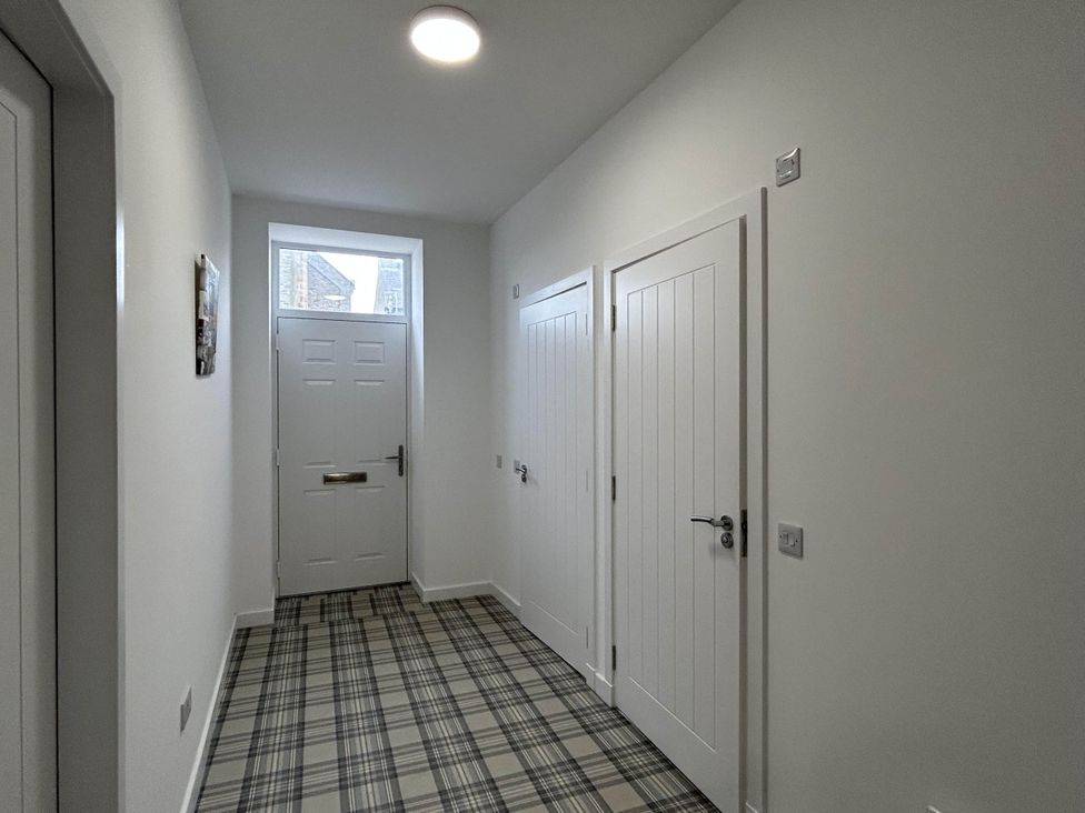 A hallway with a front door and storage doors at Buckie Haven 3 Bed Contractors Business Travellers, Buckie
