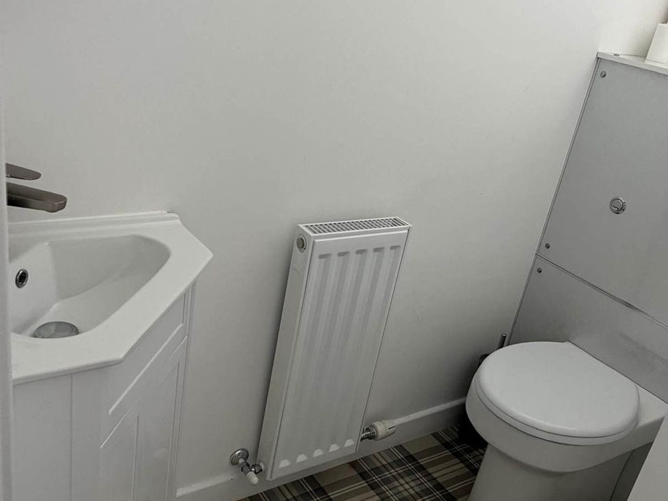 A bathroom with a sink, toilet, and radiator at Buckie Haven 3 Bed Contractors Business Travellers in Buckie