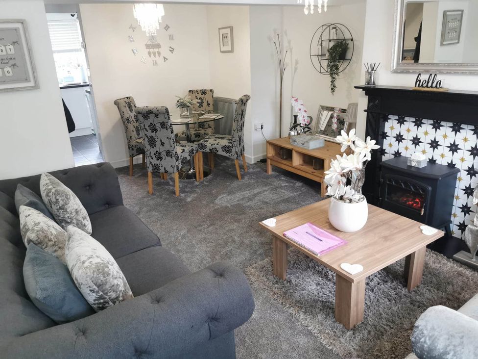 A living room with sofa, coffee table and dining area at Stunning 2-Bed House in Macclesfield Cheshire