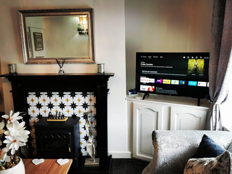 A living room with a TV and fireplace at Stunning 2-Bed House in Macclesfield Cheshire