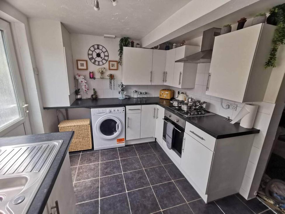 A kitchen with appliances and storage at Stunning 2-Bed House in Macclesfield Cheshire