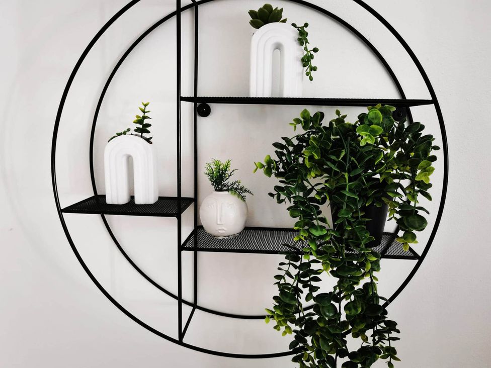 A shelf with plants and decorative objects at Stunning 2-Bed House in Macclesfield Cheshire