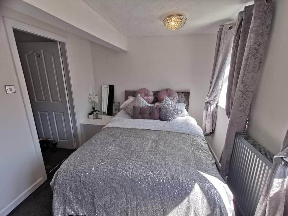 A bedroom with a bed and mirror at Stunning 2-Bed House in Macclesfield Cheshire