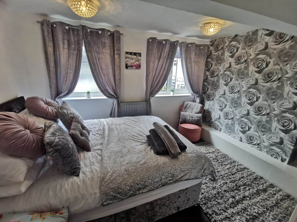 A bedroom with a bed and decorative pillows at Stunning 2-Bed House in Macclesfield Cheshire