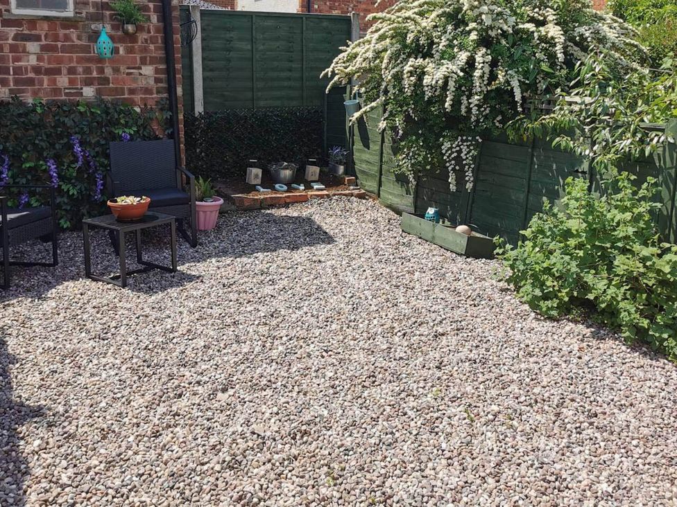 A garden with gravel and chairs at Stunning 2-Bed House in Macclesfield Cheshire
