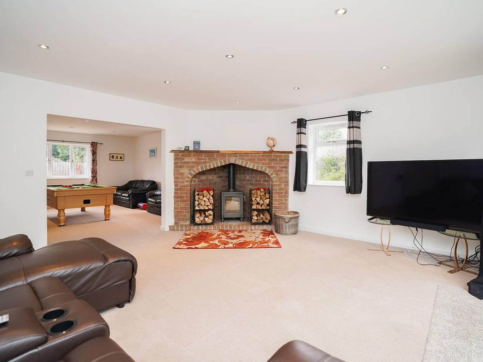 A living room with a fireplace and a pool table at Rent My Spa Home with Pool table, Hottub and Sauna in Chesterfield