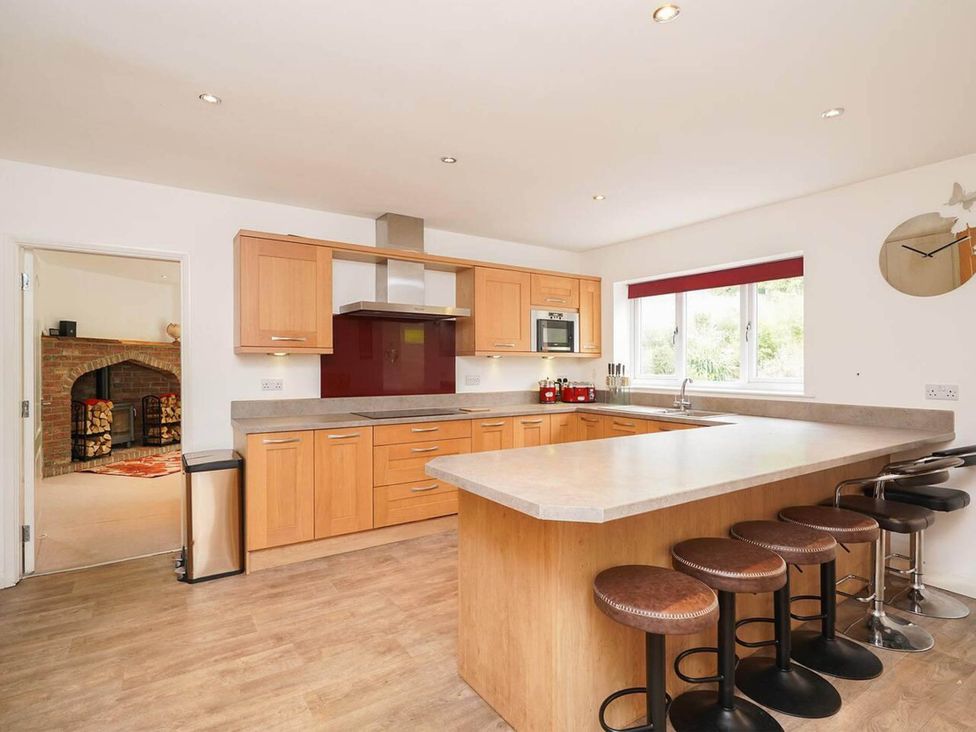 A kitchen with wooden cabinetry and bar stools at Rent My Spa Home with Pool table, Hottub and Sauna Chesterfield