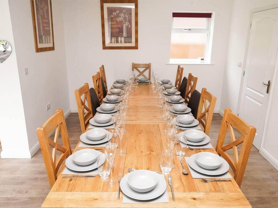 A dining room with a long table set for a meal at Rent My Spa Home with Pool table, Hottub and Sauna Chesterfield