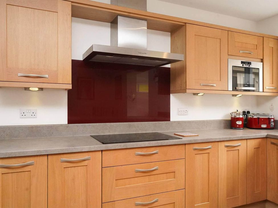 A kitchen with wooden cabinets and a stove at Rent My Spa Home with Pool table, Hottub and Sauna Chesterfield