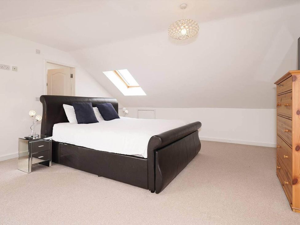 A bedroom with a bed and nightstand at Rent My Spa Home with Pool table, Hottub and Sauna Chesterfield